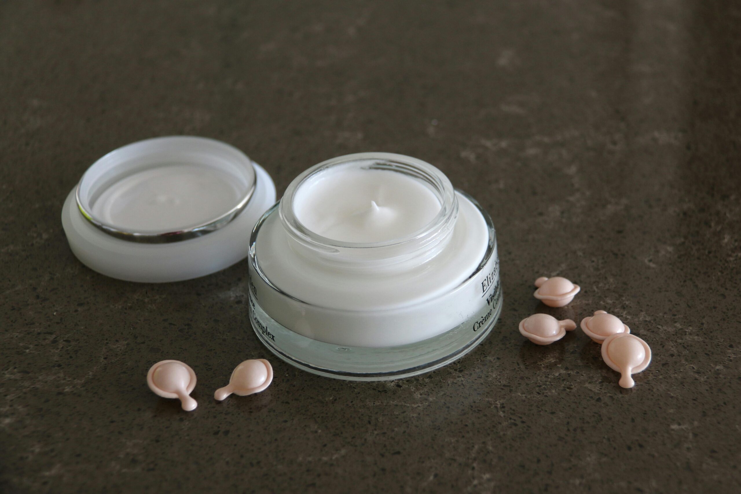 pexels photo 6645252 6645252 Open jar of luxurious face cream with capsules on a dark textured surface for skincare routines.