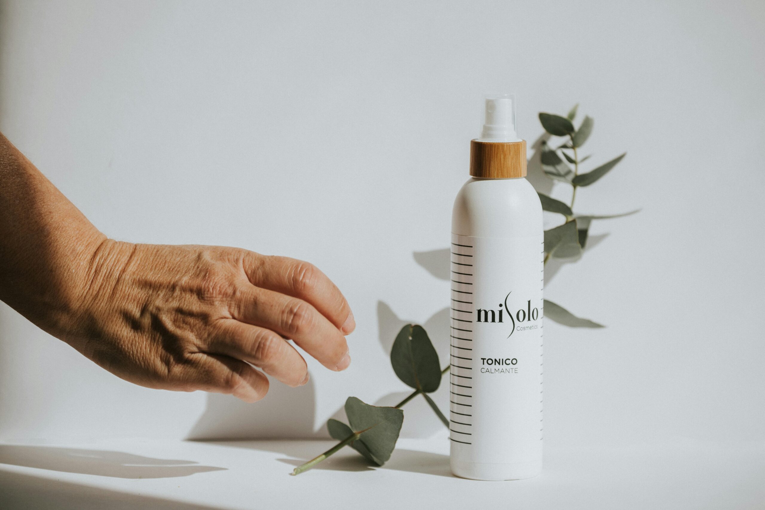 pexels photo 6767783 6767783 A soothing toner displayed with green leaves on a white surface, showcasing natural beauty.