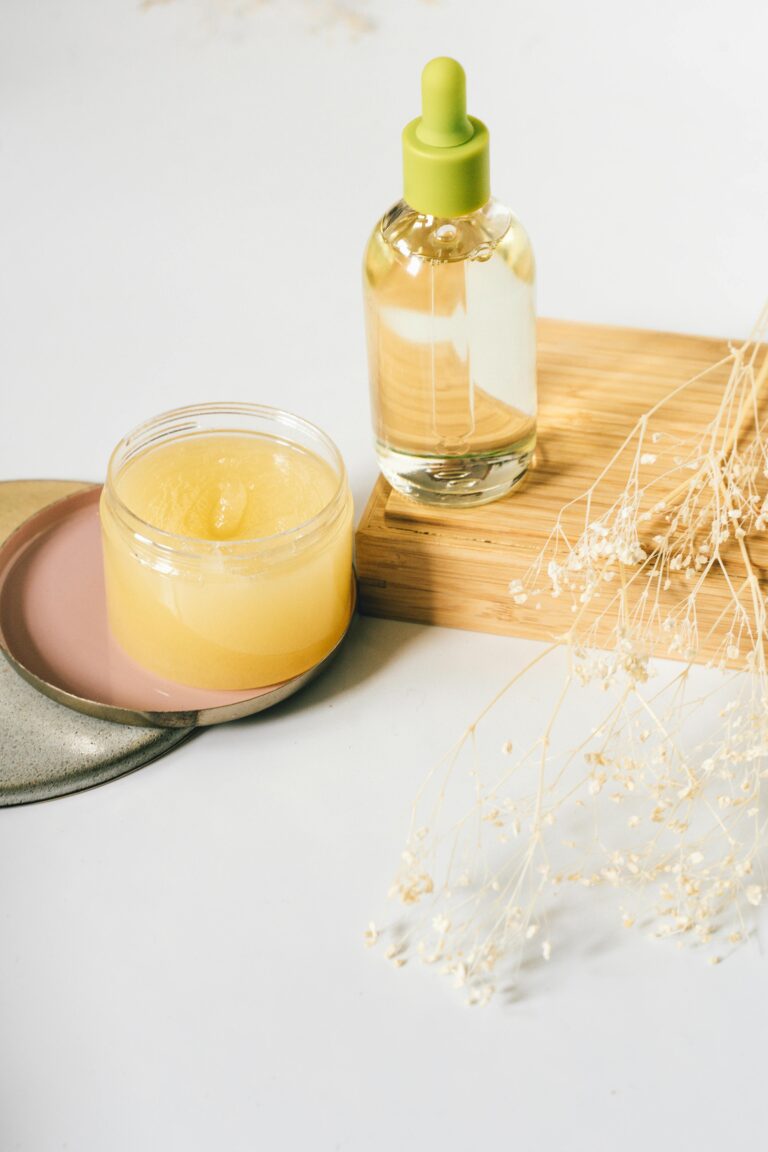 Nosotros Aesthetic display of skincare oil and balm with dried flowers on a wooden surface.
